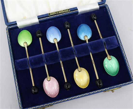 A cased set of enamel spoons
